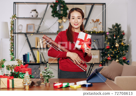 Woman posing with gift box Woman posing with gift box 72708613