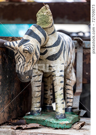 The damaged statue of zebra with a falling head, close up. The damaged statue of zebra with a falling head, close up. 72709073