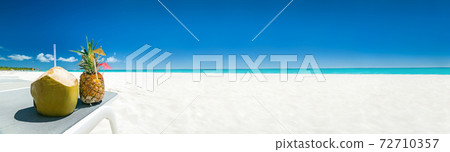 Pineapple cocktail and coconut on sandy beach. Long banner with copy space for your text 72710357