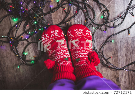 Tangled Christmas lights at feet on floor 72712171