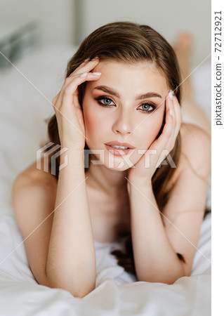 close up. portrait of beautiful woman with long hair in underwear lying on bed. close up. portrait of beautiful woman with long hair in underwear lying on bed. 72712921