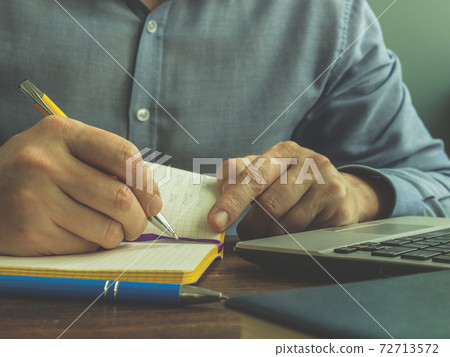 A man makes calculations in a notebook. Home finance, loans and taxes. 72713572