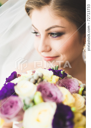 Beautiful bride wearing fashion wedding dress with feathers with luxury delight make-up and hairstyle, studio indoor photo shoot Beautiful bride wearing fashion wedding dress with feathers with luxury delight make-up and hairstyle, studio indoor photo shoot 72713733