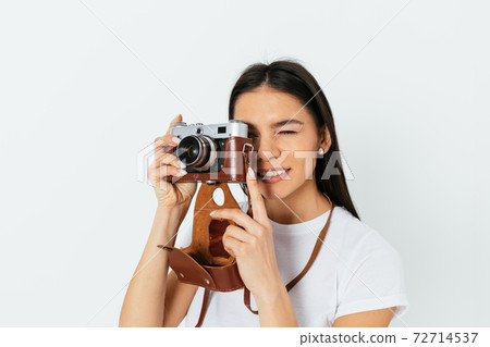Young woman takes pictures on a retro camera Young woman takes pictures on a retro camera 72714537