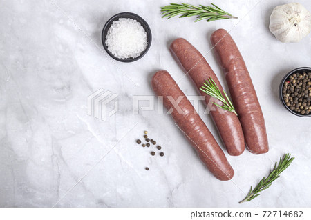 Raw meat beef sausages for grill and spicy, herbs rosemary, pepper, salt on table 72714682