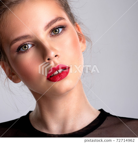 Beautiful photoshopped brown-hair girl. Pretty caucasian girl with a tilted head and red lipstick. Beautiful photoshopped brown-hair girl. Pretty caucasian girl with a tilted head and red lipstick. 72714962