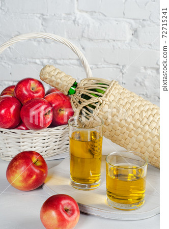 Apple juice in two glasses and apples. 72715241