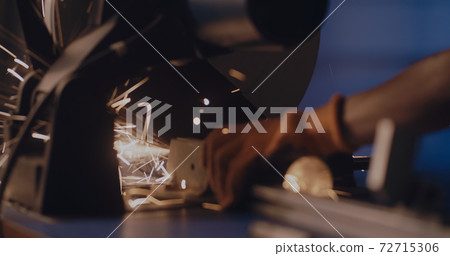 Faceless worker cutting metal pipe with saw Faceless worker cutting metal pipe with saw 72715306