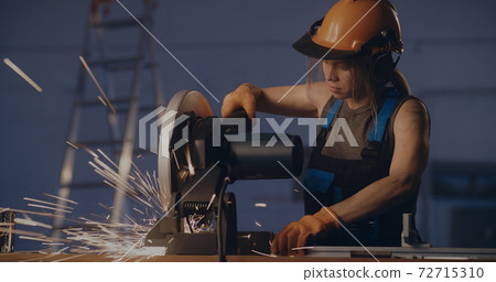 Female worker working with metal cutting saw Female worker working with metal cutting saw 72715310