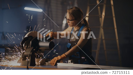 Female worker working with metal cutting saw Female worker working with metal cutting saw 72715311