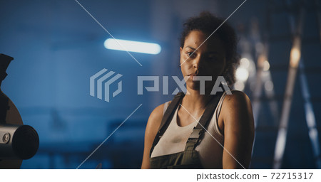Tired black woman taking hardhat after long workday Tired black woman taking hardhat after long workday 72715317