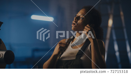 Tired black woman taking hardhat after long workday Tired black woman taking hardhat after long workday 72715318