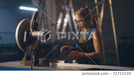 Female worker working with metal cutting saw 72715339