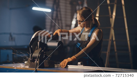 Female worker working with metal cutting saw Female worker working with metal cutting saw 72715340