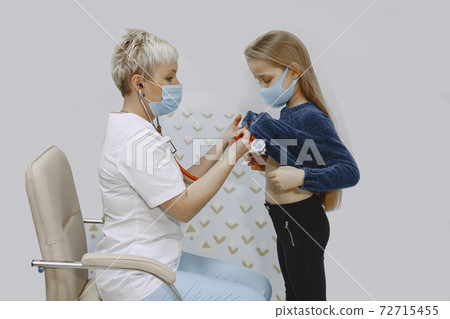 Happy little girl at the doctor for a checkup 72715455