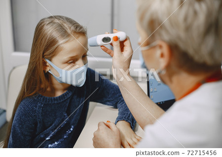 Happy little girl at the doctor for a checkup 72715456