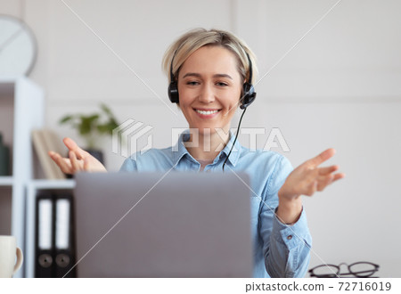 Young woman in headphones participating in educational or business online conference on laptop from home Young woman in headphones participating in educational or business online conference on laptop from home 72716019