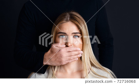Shut up and listen. Male hand closes woman mouth and prevents her from talking about feelings Shut up and listen. Male hand closes woman mouth and prevents her from talking about feelings 72716068