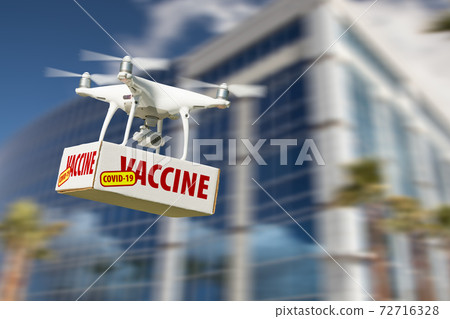 Unmanned Aircraft System (UAS) Quadcopter Drone Carrying COVID-19 Vaccine Package Near Building Unmanned Aircraft System (UAS) Quadcopter Drone Carrying COVID-19 Vaccine Package Near Building 72716328