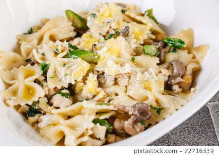 Farfalle pasta with champignon mushrooms asparagus and garlic creamy sauce 72716339