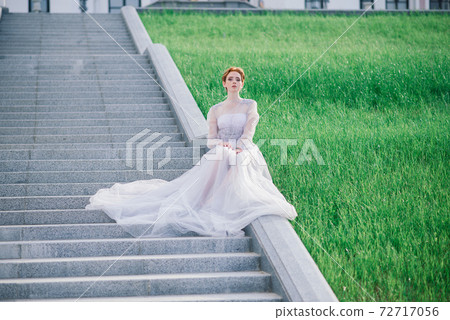 Pretty young caucasian redhead girl in garden and outside with wedding bouquet. 72717056