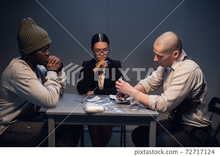 A pretty girl lawyer is present at the interrogation of a black criminal detained with drugs on the street 72717124