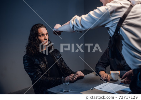 A corrupt police officer attacks a suspect in a gun trafficking case at a police station with a gun. A corrupt police officer attacks a suspect in a gun trafficking case at a police station with a gun. 72717129