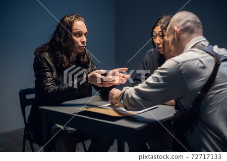A long-haired man with tattoos on his face is suspected of committing a crime and is being questioned A long-haired man with tattoos on his face is suspected of committing a crime and is being questioned 72717133
