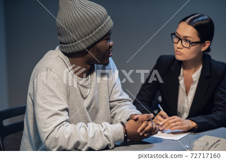 Beautiful girl investigator interrogates a young black man accused of drug distribution Beautiful girl investigator interrogates a young black man accused of drug distribution 72717160