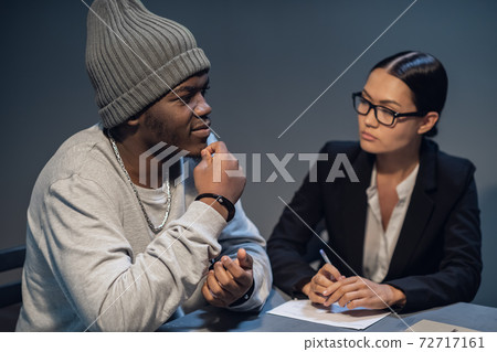 A pretty lawyer girl is having a conversation with a drug dealer client at the police station A pretty lawyer girl is having a conversation with a drug dealer client at the police station 72717161