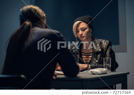 A blonde woman caught with a bag of weed is being questioned at a police station A blonde woman caught with a bag of weed is being questioned at a police station 72717164