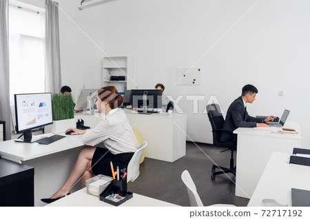 Girl Manager in a white blouse at the computer calculates the profit and loss of the company, builds charts. Monitor mockup. 72717192