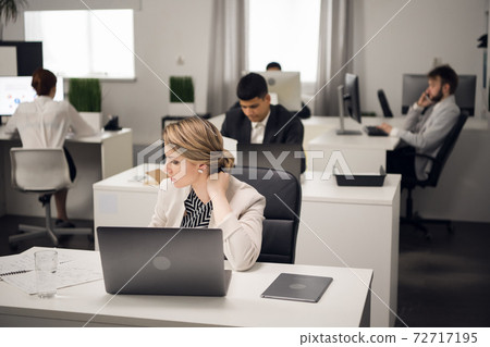 Customer service Manager at the workplace at the table with a laptop. Customer service Manager at the workplace at the table with a laptop. 72717195