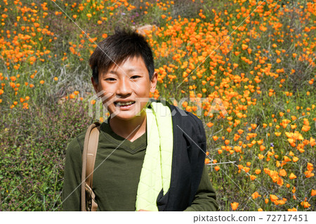 Young sporty Asian boy enjoying and hiking the mountain during the California Golden Poppy Young sporty Asian boy enjoying and hiking the mountain during the California Golden Poppy 72717451
