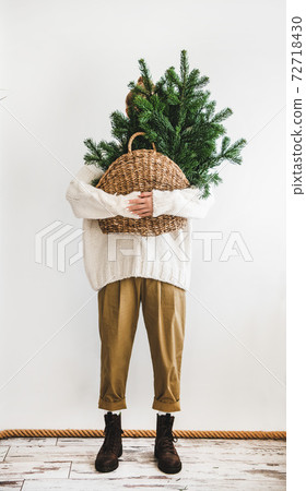 Female figure holding wicker bag with Christmas Female figure holding wicker bag with Christmas 72718430
