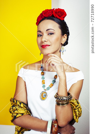 young pretty mexican woman smiling happy on yellow background, lifestyle people concept 72718990