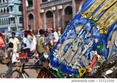 People gathering in Dhaka Shodolgat, the capital of Bangladesh, and a rickshaw parked with flashy decorations and a retro body 72721508