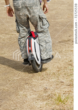 Man legs mono wheel personal electrical eco friendly transport rural scene outdoor. Man legs mono wheel personal electrical eco friendly transport rural scene outdoor. 72725539