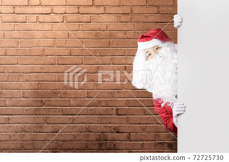 Asian man in Santa costume showing an empty board Asian man in Santa costume showing an empty board 72725730
