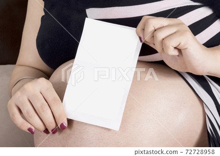 Woman holding unborn baby ultrasound X-Ray image in hands in front of belly mock-up series Woman holding unborn baby ultrasound X-Ray image in hands in front of belly mock-up series 72728958