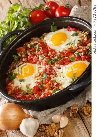 Ajarian Chirbuli is a dish from Georgia Ajara region made with eggs, tomatoes, onion and walnuts, it is a popular breakfast meal closeup. Vertical Ajarian Chirbuli is a dish from Georgia Ajara region made with eggs, tomatoes, onion and walnuts, it is a popular breakfast meal closeup. Vertical 72729768