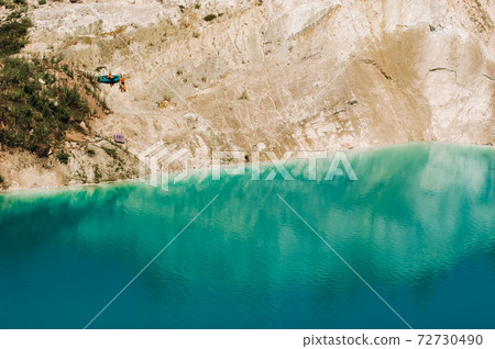 Vaukavysk chalk pits or Belarusian Maldives are beautiful saturated blue lakes.Two tourists pull a boat out of the water Belarus. Vaukavysk chalk pits or Belarusian Maldives are beautiful saturated blue lakes.Two tourists pull a boat out of the water Belarus. 72730490
