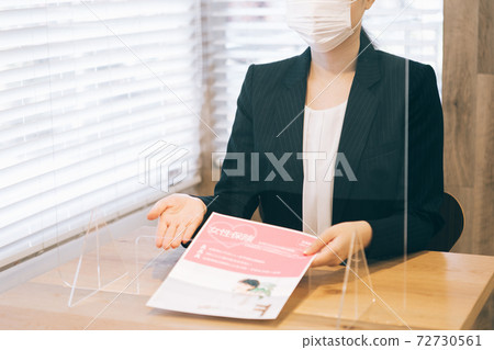 戴著面具的女人通過丙烯酸板為客戶服務 72730561