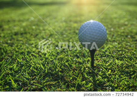 Golf ball on tee in beautiful golf course at sunset background Golf ball on tee in beautiful golf course at sunset background 72734942