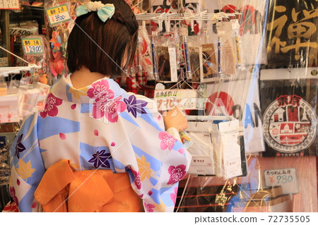 One woman in a kimono who chooses souvenirs, back view 72735505