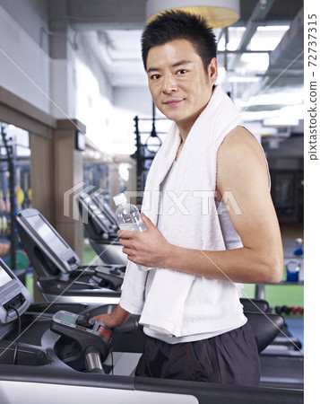 asian man taking a break while exercising on treadmill asian man taking a break while exercising on treadmill 72737315