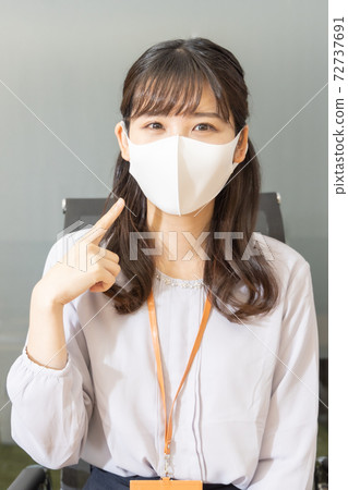 A woman pointing and confirming wearing a mask A woman pointing and confirming wearing a mask 72737691