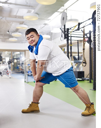 overweight young asian man exercising in fitness center overweight young asian man exercising in fitness center 72737901