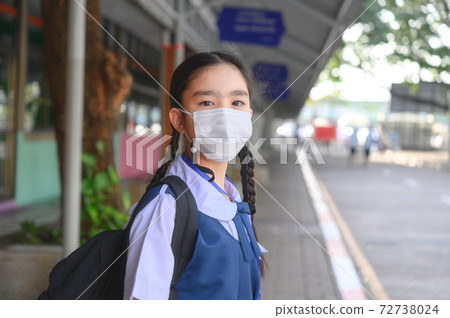 Back to school. asian child girl wearing face mask with backpack going to school .Covid-19 coronavirus pandemic.New normal lifestyle.Education concept.. 72738024
