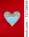 White heart with a blue face mask on a red background. Concept of a Valentines day during Coronavirus or Covid pandemic. 72738036